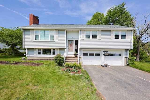 split foyer home with a chimney, driveway, an attached garage, and a front lawn