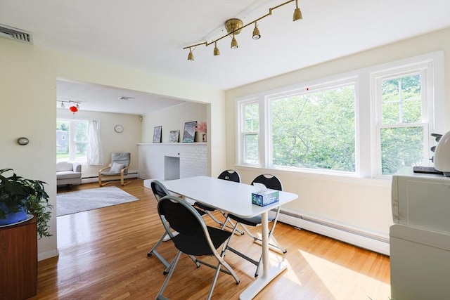 home office featuring baseboard heating and wood finished floors