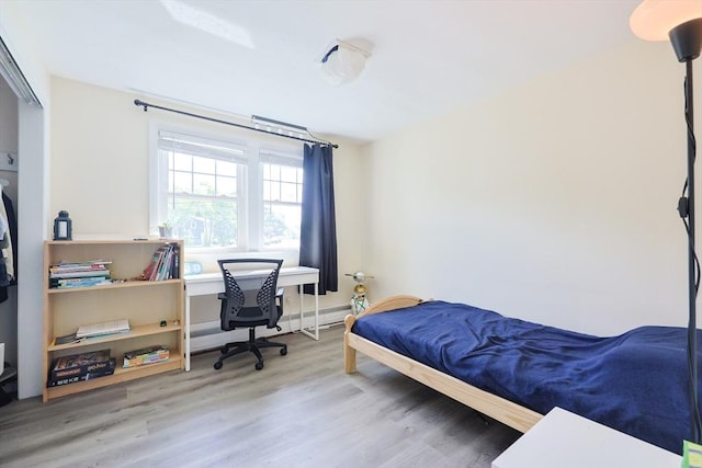 bedroom with wood finished floors and an office area