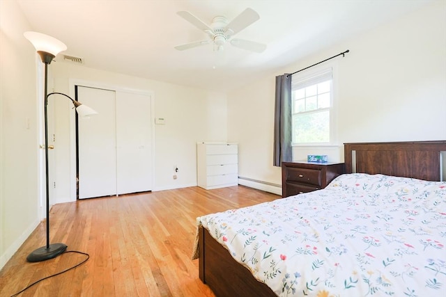 bedroom featuring baseboard heating, light wood-style floors, baseboards, and ceiling fan
