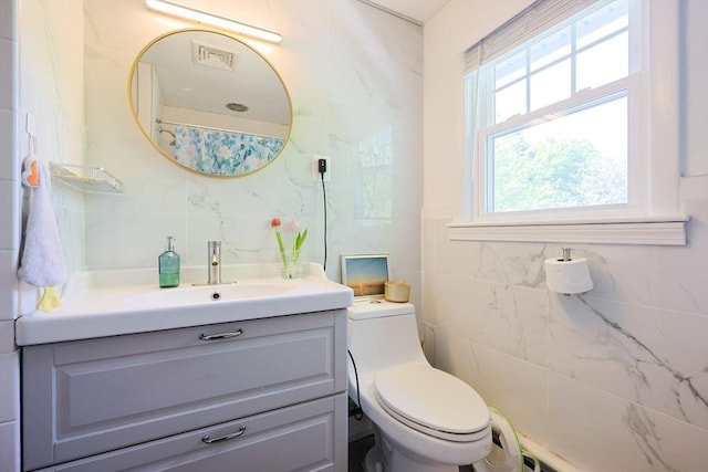 bathroom featuring tile walls, tasteful backsplash, vanity, and toilet
