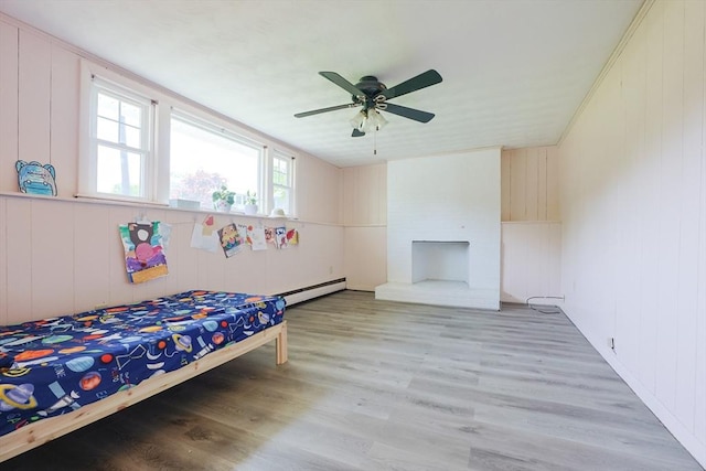 bedroom featuring baseboard heating, light wood-style floors, and ceiling fan