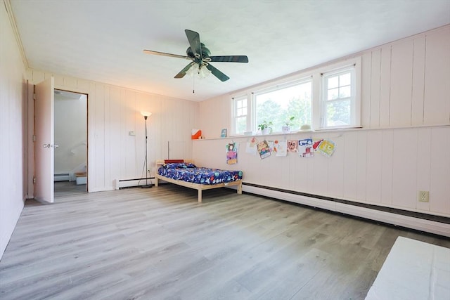 bedroom with a baseboard heating unit, wood finished floors, a baseboard radiator, and a ceiling fan