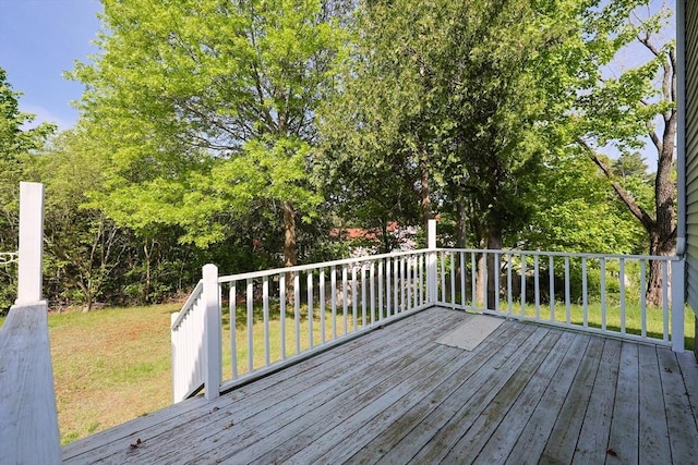 wooden terrace featuring a lawn