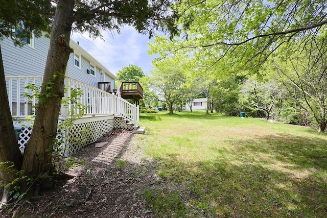 view of green lawn with a deck and stairs