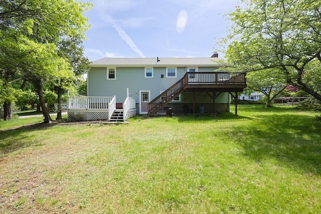 back of property featuring a wooden deck, stairway, a yard, and a chimney