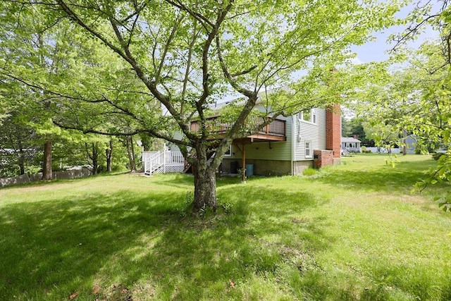 view of green lawn featuring a wooden deck