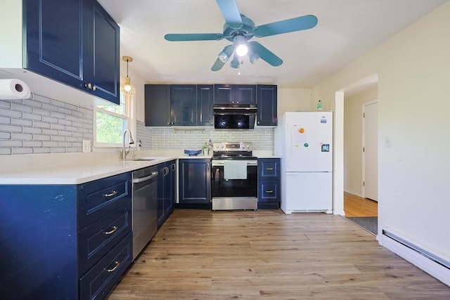 kitchen with stainless steel appliances, a baseboard heating unit, blue cabinetry, a sink, and tasteful backsplash