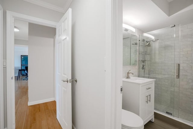 bathroom featuring crown molding, hardwood / wood-style floors, vanity, an enclosed shower, and toilet