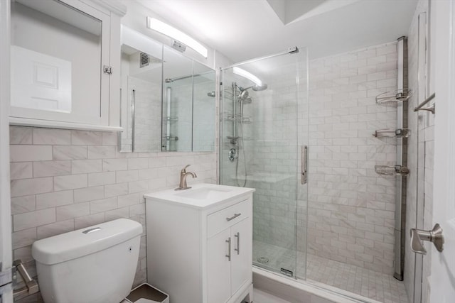 bathroom featuring vanity, toilet, tile walls, and walk in shower