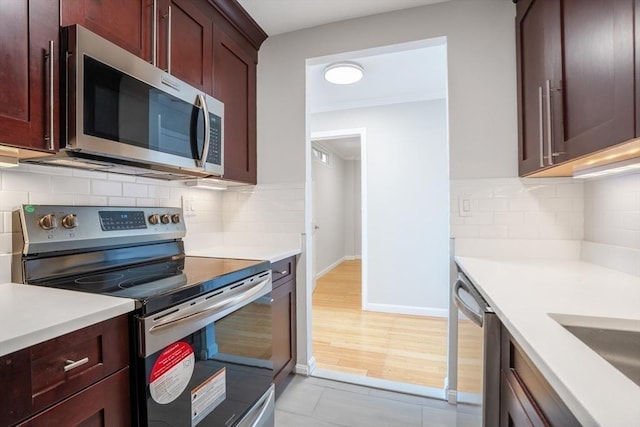 kitchen featuring light tile patterned floors, backsplash, and appliances with stainless steel finishes