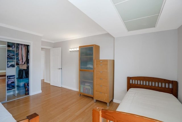 bedroom with ornamental molding, wood-type flooring, and a closet