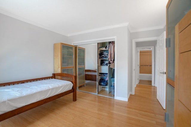 bedroom with ornamental molding, light hardwood / wood-style flooring, and a closet