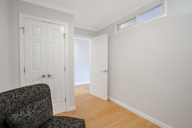 living area featuring ornamental molding and light hardwood / wood-style flooring