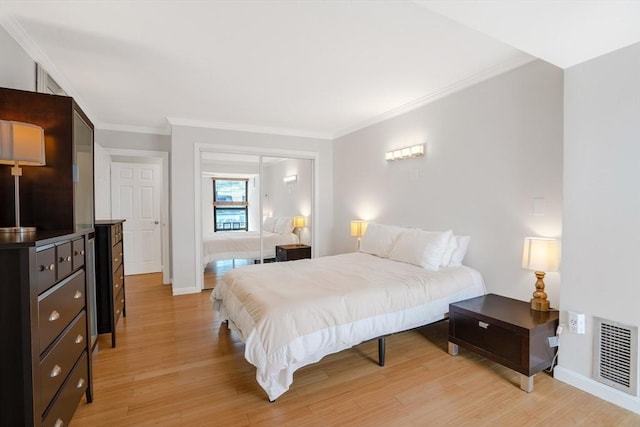 bedroom featuring ornamental molding and light hardwood / wood-style floors