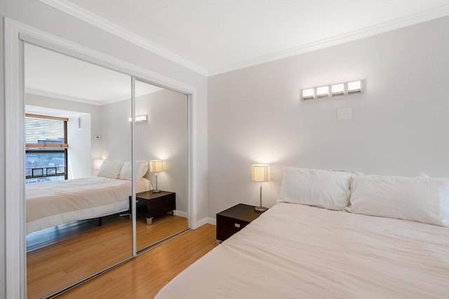 bedroom with crown molding, wood-type flooring, and a closet