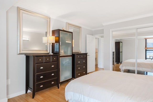 bedroom featuring ornamental molding, light hardwood / wood-style floors, and a closet