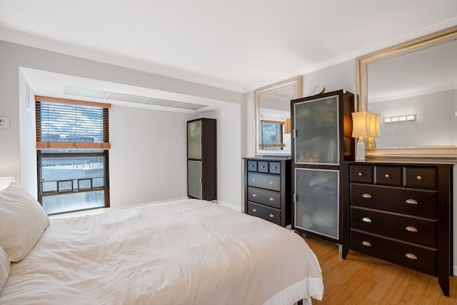 bedroom featuring crown molding and light wood-type flooring