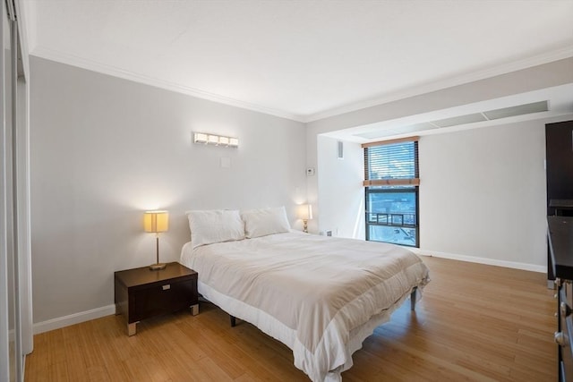 bedroom featuring ornamental molding and light wood-type flooring