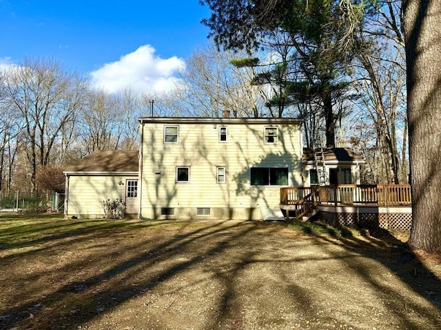 back of house featuring a wooden deck and a yard