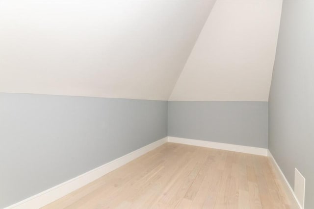 bonus room featuring lofted ceiling and light wood-type flooring