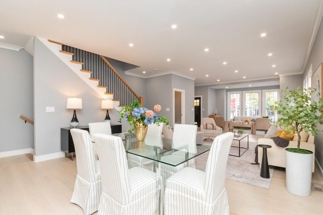 dining room featuring ornamental molding and light wood-type flooring