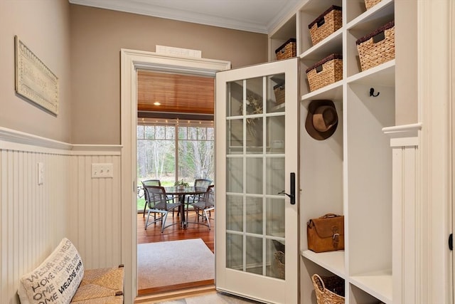 mudroom featuring wainscoting, crown molding, and wood finished floors