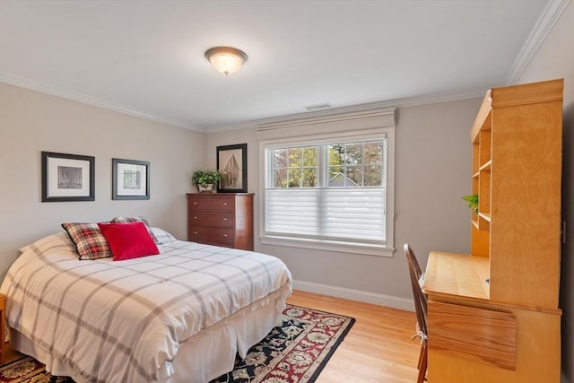 bedroom featuring light wood finished floors, ornamental molding, and baseboards