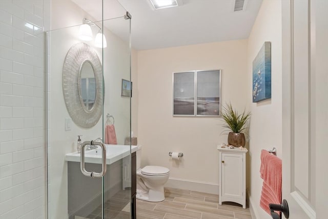 bathroom with toilet, wood tiled floors, baseboards, and vanity