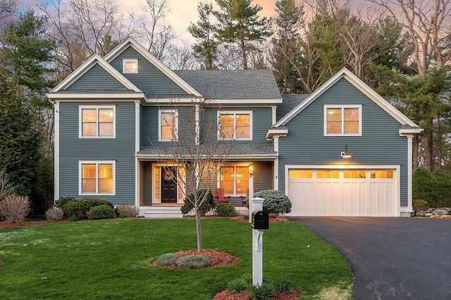 craftsman house featuring a porch, driveway, an attached garage, a yard, and a shingled roof