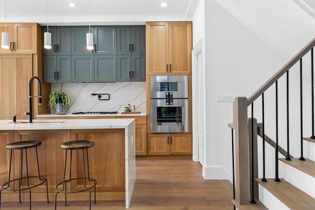 43 Wendell St Unit 0, Cambridge, MA 02138 - kitchen with a breakfast bar area, light wood-type flooring, recessed lighting, a sink, and backsplash