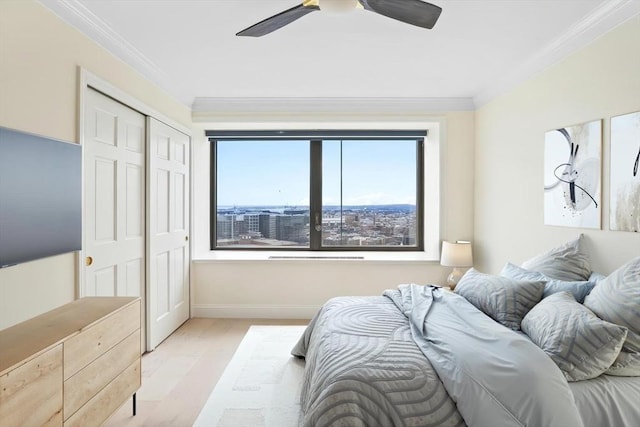 85 E India Row Unit 36D, Boston, MA 02110 - bedroom with crown molding, baseboards, light wood-style flooring, a ceiling fan, and a closet