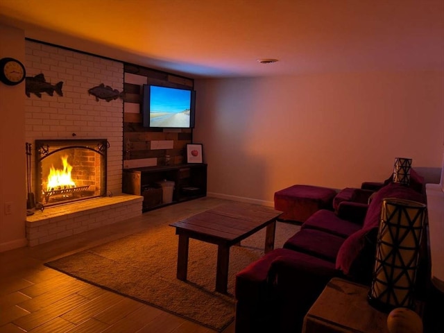 living room featuring wood-type flooring and a brick fireplace