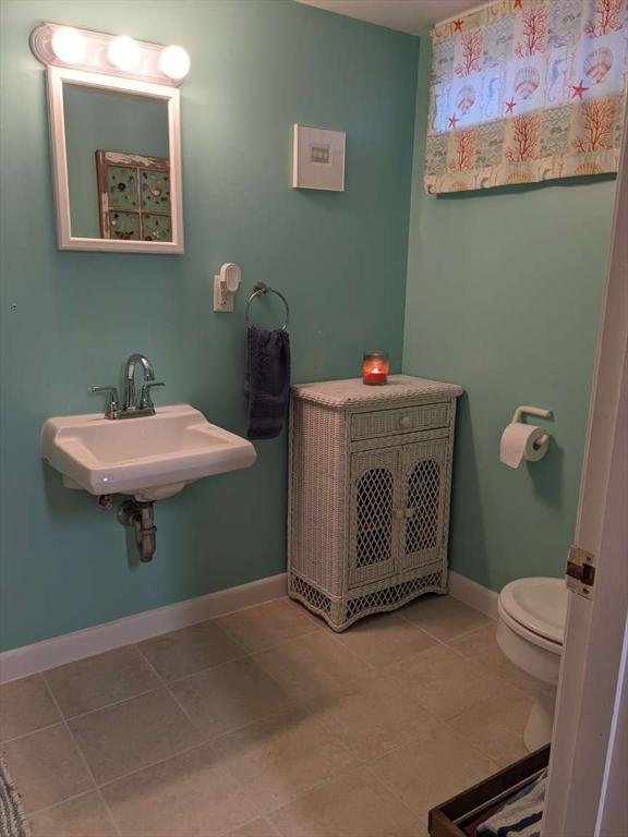 bathroom featuring tile patterned flooring, toilet, and sink