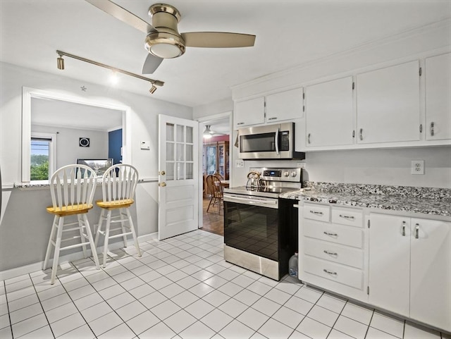 11 View St, Dracut, MA 01826 - kitchen with appliances with stainless steel finishes, ceiling fan, white cabinetry, rail lighting, and light tile patterned floors