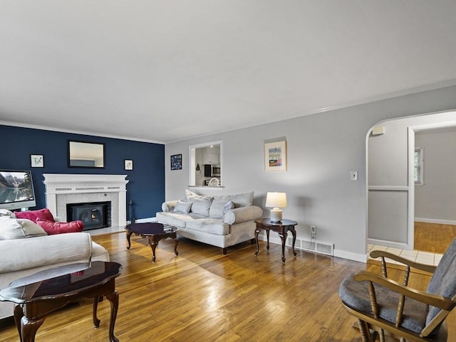 11 View St, Dracut, MA 01826 - living room with a tiled fireplace, wood finished floors, ornamental molding, baseboards, and arched walkways