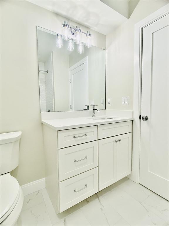 15 Yuill Cir Unit 3, Boston, MA 02136 - bathroom with marble look tile flooring, toilet, vanity, and baseboards