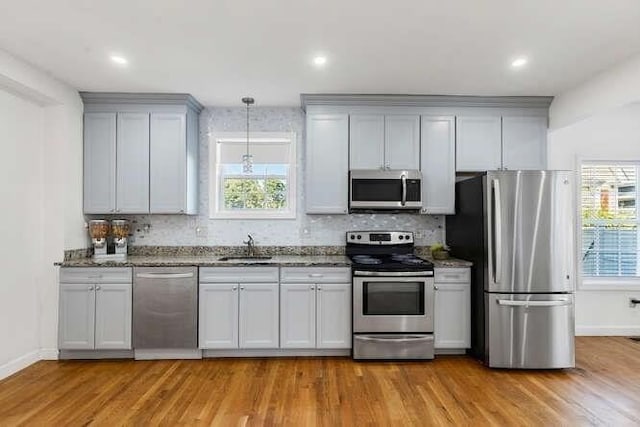 18 Anderson St, Lowell, MA 01852 - kitchen featuring stainless steel appliances, backsplash, light wood-type flooring, and recessed lighting