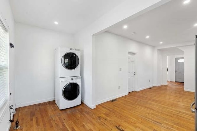 18 Anderson St, Lowell, MA 01852 - washroom featuring stacked washing machine and dryer, light wood-type flooring, baseboards, and recessed lighting