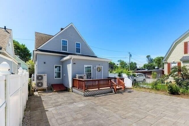 18 Anderson St, Lowell, MA 01852 - rear view of property featuring a patio, a deck, a fenced backyard, and a cooling unit