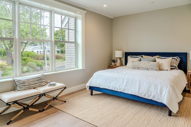 bedroom with hardwood / wood-style floors and multiple windows