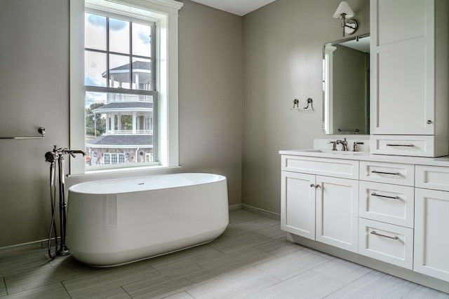 bathroom with vanity, plenty of natural light, and a tub to relax in