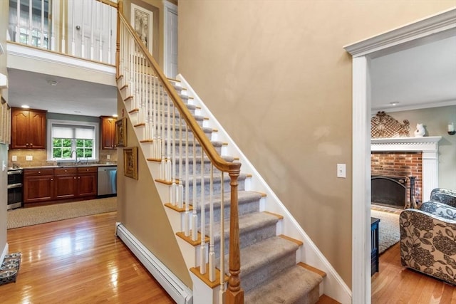 14 Cushman Lndg, Plympton, MA 02367 - stairway with a baseboard radiator, hardwood / wood-style flooring, a brick fireplace, and ornamental molding