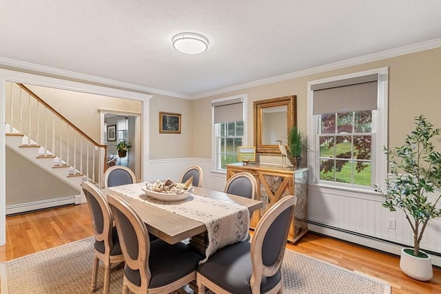 14 Cushman Lndg, Plympton, MA 02367 - dining space featuring a baseboard heating unit, light wood-style floors, crown molding, stairs, and a wainscoted wall