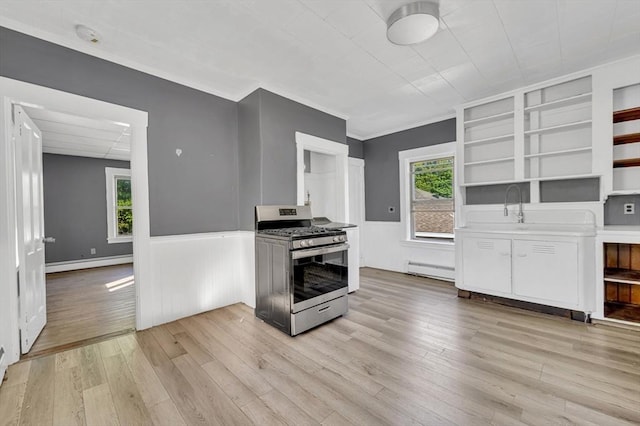 kitchen with gas stove, open shelves, a baseboard heating unit, white cabinetry, and wainscoting