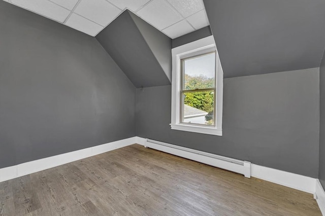 bonus room with a baseboard heating unit, wood finished floors, baseboards, and vaulted ceiling