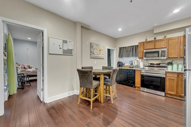 kitchen featuring appliances with stainless steel finishes, dark wood-style flooring, light countertops, baseboards, and recessed lighting
