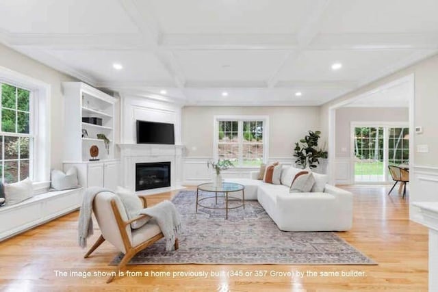 363 Grove St, Reading, MA 01867 - living room with plenty of natural light, recessed lighting, beamed ceiling, a fireplace with flush hearth, and wood finished floors