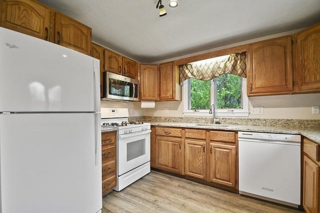 125 Chapin Rd Unit 3F, Hudson, MA 01749 - kitchen featuring white appliances, a sink, light wood-style floors, brown cabinets, and light stone counters