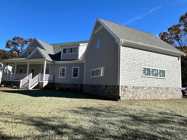 view of side of property with a porch and a yard